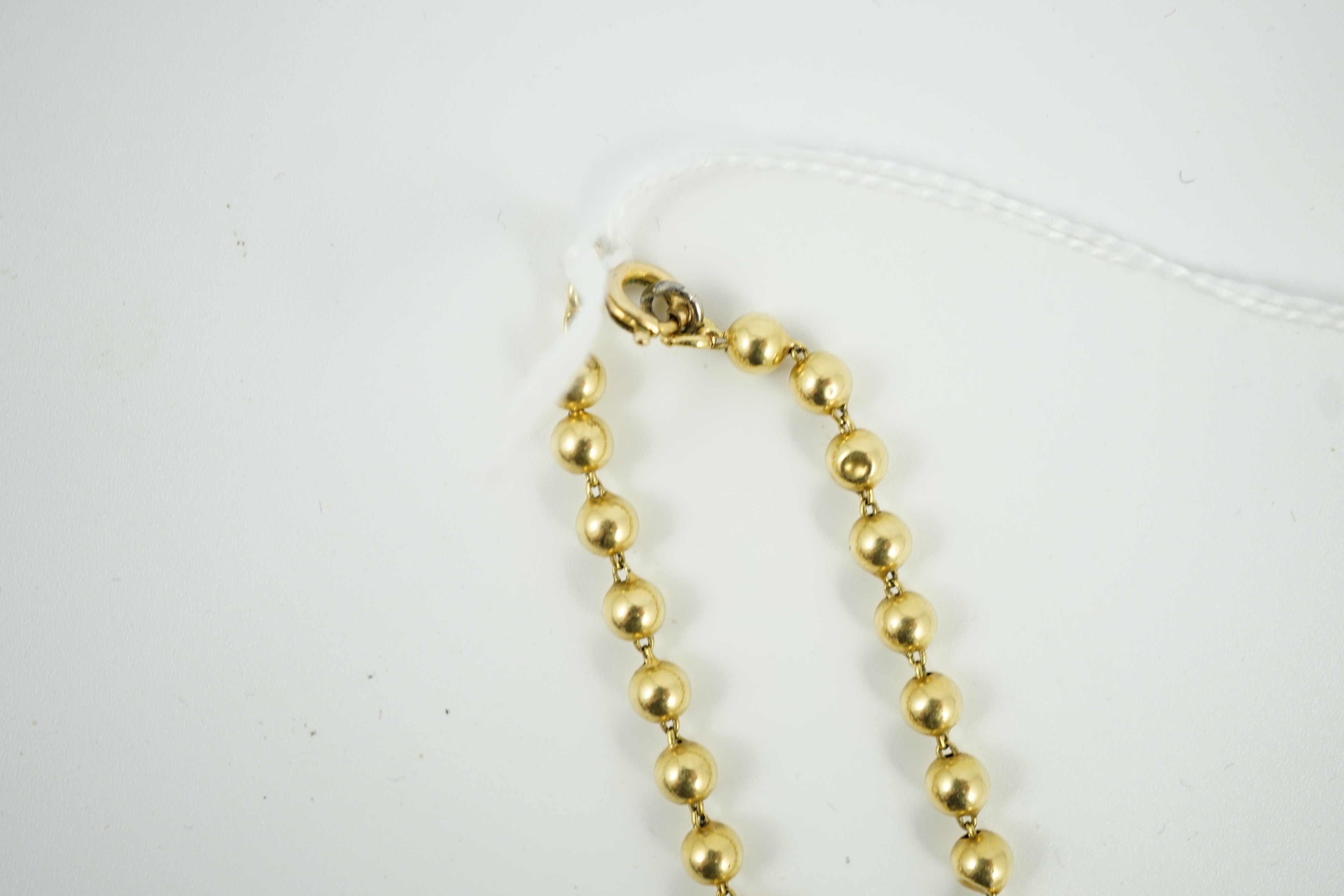 A French? graduated yellow metal bead necklace, 42cm, gross 21.4 grams.